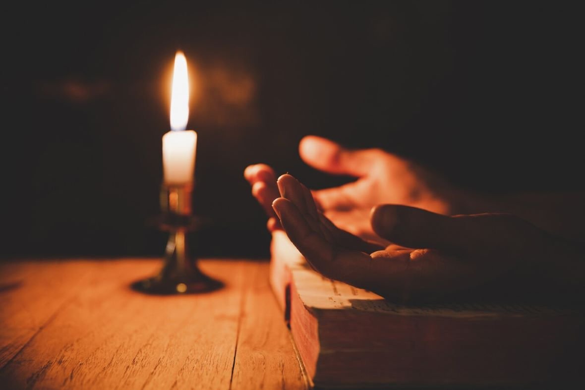 hand is praying church with lit candle 1150 9242 1 - Home